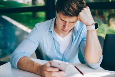 Mutsuz hipster öğrenci sinirli modern smartphone ücretsiz 4 g kullanarak bilgileri okuduktan Web sitesinde kötü sonuçlar internet. Karışık genç adam cep haber hayal kırıklığı ile bildirimi alındı