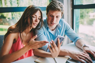 4 g internet bağlantısı kullanarak modern smartphone aygıtında web sitesinde yeni programı tartışırken aşık kaç. Genç evlilik kafede birlikte vakit dijital telefon video blog izlerken