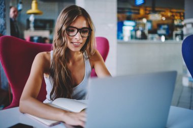 Gözlük vizyon düzeltme kafe, pozitif öğrenci netbook üzerinde USB'yi seminer eğitimi için hazırlanıyor modern dizüstü klavye metin bilgileri yazarak müreffeh genç kadın