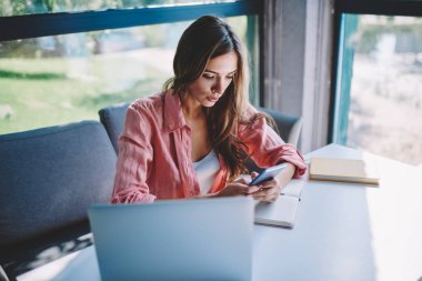 E-posta ile bildirim 4 g kullanarak modern smartphone cep telefonu ile kontrol hipster kadın blogger café.Millennial genç kadın online telefon aygıtı kafede sohbet bilgisayar oturup internet