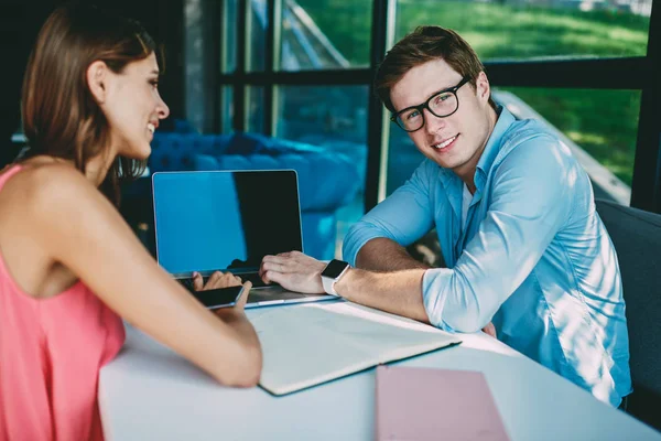 成功学生的肖像微笑 同时与年轻女子合作在现代 Coworking 空间的考试准备中使用便携式计算机进行项目的生产性工作 — 图库照片