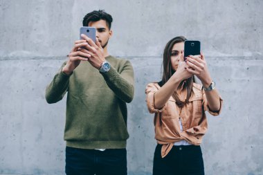 Cep telefonları online sohbet üzerinde konsantre yüzlerini önünde gerçek hayat iletişim görmezden tutan gençler, modern akıllı telefonlar ayakta duvara bağımlısı erkek ve kadın arkadaş
