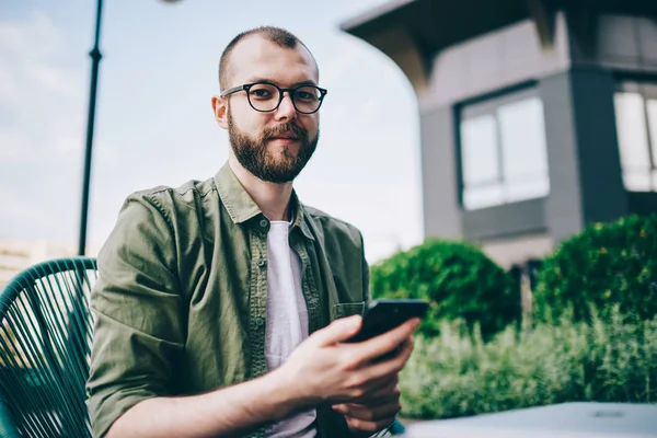 Portretul Unui Tânăr Barbă Ochelari Care Ține Telefonul Mâini Actualizează — Fotografie, imagine de stoc