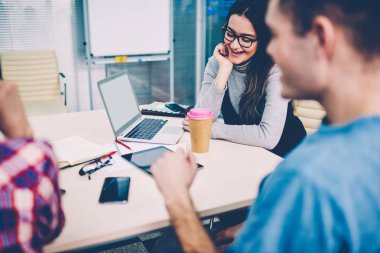 Tablo modern dizüstü bilgisayar Office ile Toplantı oturma tasarım projenin geliştirilmesi üzerinde işbirliği yaratıcı gençlerin başarılı takım. Beyin fırtınası sırasında fikirleri tartışmak öğrenciler