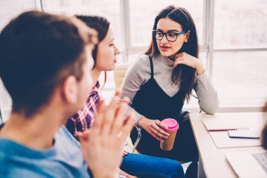 Kahve molası modern ofis zevk birbirleriyle iletişim yaratıcı öğrenciler rahat giyinmiş. Konuşma ve çalışma programı işbirliği toplantısı sırasında tartışırken iş arkadaşları