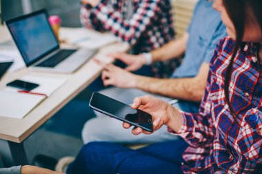 Görünümünü modern smartphone tutan kadın eli kırpılmış aygıt ve parmağında ile yazarak metin iletisi göndermek için görüntü. Hippi kız profil sayfası cep telefonu 4 g internet bağlantısı kullanarak güncelleştirme