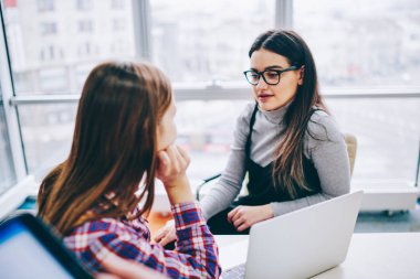 Office'te çalışma sürecinde ortak proje üzerinde işbirliği planı tartışmaya iki profesyonel kadın tasarımcılar. İş arkadaşları birbirleriyle tatilinde masadan dizüstü bilgisayar ile iletişim kurmak