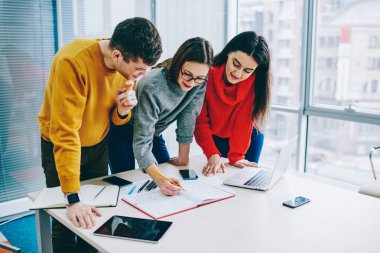 İşbirliği genç profesyonellerin ofiste yeni proje tasarımını oluşturma. Takım başarılı hipster öğrencilerin ortak eğitim görev üzerinde beyin fırtınası sırasında işbirliği rahat kıyafet giymiş