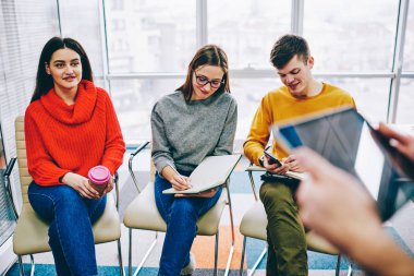 Başarılı öğrenci grubu sandalyelere oturan ve iş eğitim notları not defterinde yapım sırasında Koç dinlerken rahat kıyafet giymiş. Atölye modern ofis profesyonel tasarımcılar için