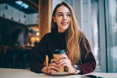 Kahve molası Üniversitesi sonra uzağa sevimli gülümseme ile yüz, Genç olumlu hipster kız casual giyinen dinlenme ve bekleyen arkadaş rahat kafeteryada bakarken zevk neşeli kız öğrenci