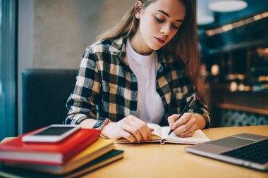 Üniversitesi Kütüphanesi'nde ders kitabı, çekici konsantre kadın kapalı defter kafeteryada ziyaret inceleme yazma sürecinde çalışma planlama yaparken vakit ciddi kadın serbest meslek