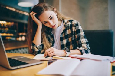 Modern dizüstü bilgisayar ve kitap kapalı, kullanarak soru için cevap bulmak önemli sınav çalıştığım için hazırlanıyor yorgun kız öğrencinin ders çalışma Üniversitesi Kütüphanesi'nde kadın duygu baş ağrısı konsantre