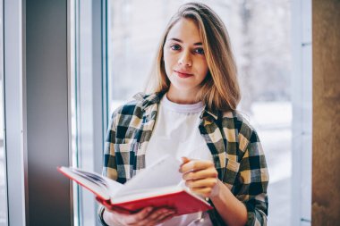 Güzel hippi kız kameraya ise ilginç bir kitap elinde tutan ve Üniversite Kütüphanesi, bekleyen arkadaşıyla kadın genç giyim rahat bakmak kapalı edebiyat zevk çekici