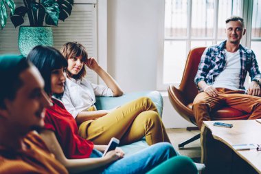 Genç kişilik ekibin çalma sırasında rahat kıyafet dinleme arkadaş giyinmiş şık ev iç ile modern daire içinde oyun. Hipster harcama zaman birlikte konforlu hostel odasında çocuklar