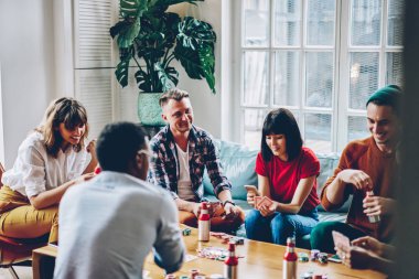 Pozitif çok kültürlü arkadaşlar birlikte şık daire içinde toplantı sırasında poker oynamaya ücretsiz vakit. Neşeli hipster rahat masa oyunları ve eğlence hafta sonu zevk giyiyor