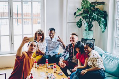 Rahat kıyafet yapma selfie fotoğraf makinesinde açık modern smartphone için blog reklam harcama zaman birlikte evinde poker oynamaya yayında pozitif çok kültürlü arkadaşlar giymiş