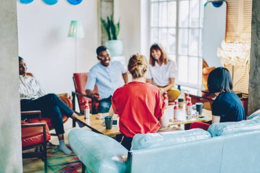 Arkadan görünüm gençlerin içki masasında şık apartman dairesinde dostu toplantı sırasında oyun oynarken rahat kıyafet giymiş. Çok kültürlü hipster çocuklar hafta sonu birlikte dairede geçirmeye eğleniyor