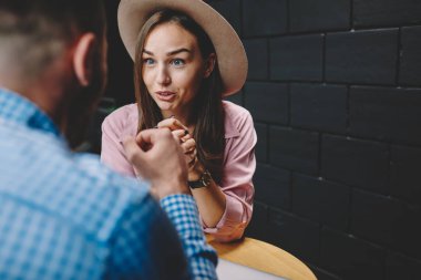 Sürpriz şık casual giyimli genç kadın kafeteryada kalma sırasında şok haber erkek arkadaşıyla tartışmaya şapkalı. Kafede toplantı sırasında güzel adamla konuşmak güzel hippi kız hayran
