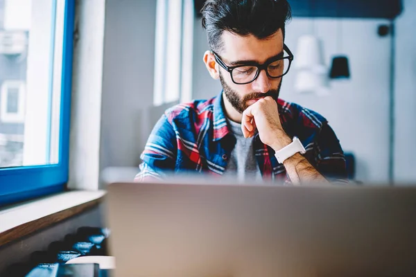 Nachdenklicher Männlicher Werbetexter Mit Brille Der Zeit Mit Modernem Laptop — Stockfoto