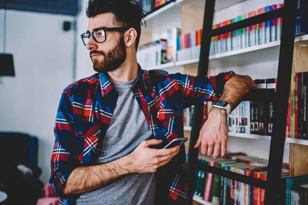 Geconcentreerde Hipster Man Tijd Doorbrengen Bij Universiteitsbibliotheek Tijdens Het Wachten — Stockfoto