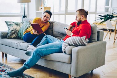 Hippi kız ilginç gösterilen kitap sevgilisi birlikte daire, Genç aile iletişim bestseller harcama hafta sonları tartışırken rahat kanepe, istirahat için 