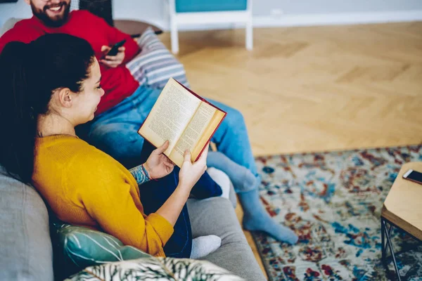 Beskuren Bild Kvinnliga Sitter Med Bok Bredvid Pojkvän Soffan Hemma — Stockfoto