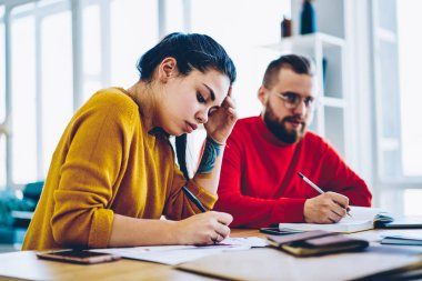 Araştırmalar, ciddi hippi kız ve Masaüstü için sınav hazırlama ve notlar, oturan adam konsantre ev ödevi yazma ve erkek öğrenciler dalgın meslektaşları planlama projesi