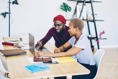 Dizüstü bilgisayar, Masaüstü, Afrikalı-Amerikalı çift araya Gözat web sayfası netboo üzerinde rezervasyon yapmadan oturan kadın meslektaşı uygulama yükleme ciddi koyu tenli hipster adam