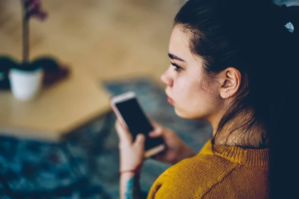 電話を待っている携帯電話を保持して物思いにふける千年内気な少女の背面図 思慮深いブルネットの女性探しの Cellula を使用してテキスト メッセージのための考えに離れて熟考のイメージ アップ — ストック写真