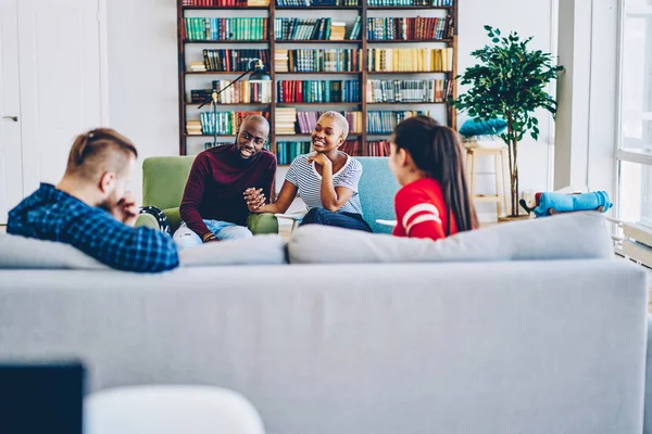 年轻的非洲裔美国人夫妇会见客人在舒适的客厅有积极的交谈 多种族的男性和女性嬉皮士在公寓里互相交谈免费蒂姆 — 图库照片