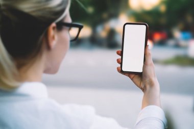 Kırpılan geri modern smartphone ile boş ekran alanı Internet içeriğine yönelik tutan genç kadının görüntüleyin. Hippi kız ön kamera dijital telefon sahte alanı ile selfie yapma