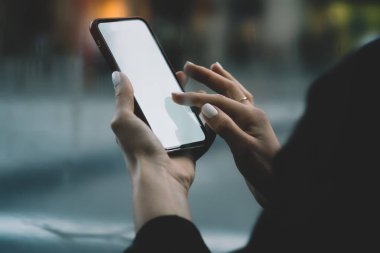 Holding modern smartphone ile boş ekran alanı Internet içerik için kadının eller görünümünü kırpılmış. Dijital cep telefonu ekranda metin mesajı yazmaya parmak. Online ödemede cep
