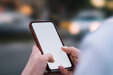 Smartphone ile boş ekran alanı Internet içeriğine yönelik Web sitesinde holding kadının eller görünümünü kırpılmış. Telefon sahte alanı ile kısa mesaj yazarak parmaklar üzerinde seçici odak