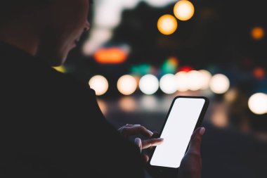 Modern cep telefonu elinde tutan ve 4 g kullanarak aygıt üzerinde app güncelleme hipster kadın blogger görünümünü kırpılmış Internet üzerinde bokeh arka plan. Genç kadın cep boş ekranda parmağınızla yazmaya