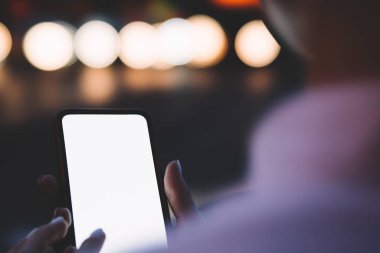 Smartphone ile sahte alanı kurmak için internet içerik tutan eller veya Web sitesi görünümünü bokeh arka plan üzerinde kırpılmış. Metin reklam için boş ekran alanı ile dijital cep telefonu