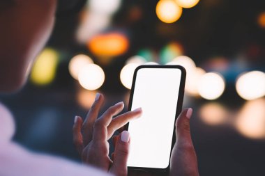 Kadın görünümünü kırpılmış ' s modern smartphone aygıt tutarak ve parmak ile ile boş ekranda dokunmadan eller bokeh arka plan üzerinde app yüklemek için yer alan Internet içeriğine yönelik kopyalama