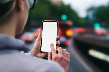 Akıllı telefon tutarak ve app yükleme için 4 g internet bağlantısı kullanarak Gadget boş ekranda parmağınızla yazmaya kadının elleri arkadan görünüm kırpılmış. Kopyalama alanı alanı ile dijital cep telefonu