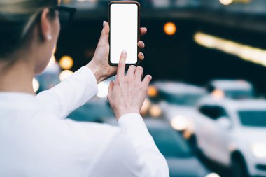 Parmak ile akıllı telefon boş ekran dokunaklı ve sosyal ağlar için fotoğraf yapma genç kadın arkadan görünüm kırpılmış. Web siteniz için kopyalama alanı alanı ile telefon tutarak hipster blogger