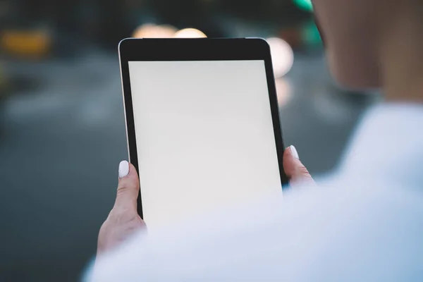 Cropped view of modern touch pad device with blank screen in woman\'s hands on bokeh background.Woman\'s hands holding digital tablet with copy space area for your internet advertisement