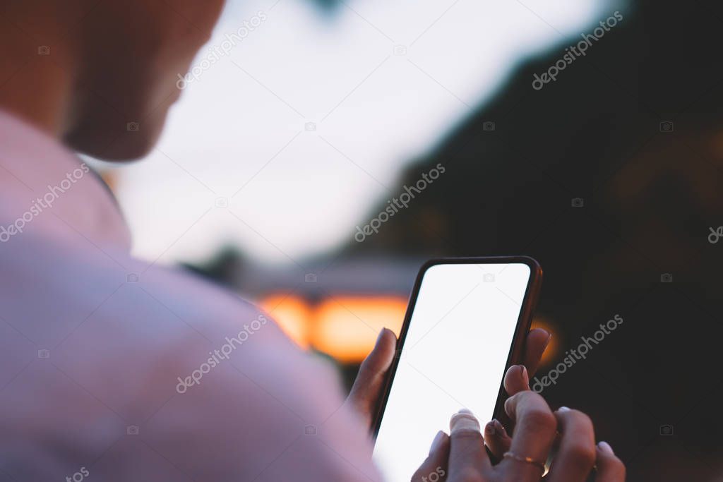 Cropped view of female finger typing on blank display of smartphone with copy space area for your internet website and advertising message.Woman's hands holding cellular with mock up area