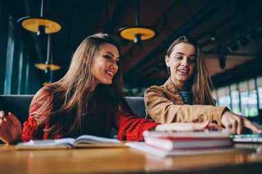 Ders çalışma için araştırma yapmak ve üniversite ödev yapmak başarılı hipster kız gülümseyerek olumlu kadın gazeteciler beraberlik vasıl okul sırası ile edebiyat, oturup kafeterya çalışan