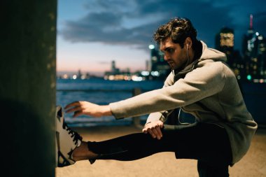 Erkek koşucu esneklik egzersizleri dinleme motivasyon sesli kitap yolu ile elektronik kulaklık, genç sporcu eğitim kas açık havada sırasında vücut dengesi ile yardım için egzersiz işlem ekleme