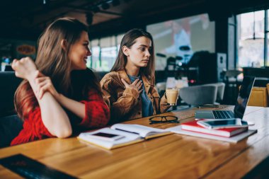 Kahve molası bekleyen webinar online kafeterya wifi için bağlı dizüstü bilgisayarda zevk iki büyüleyici hippi kız birlikte genç güzel kız öğrencilerin üniversiteye hazırlık test