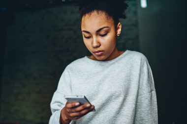 Ciddi Afro-Amerikan Kız 4 g internet bağlantısı kullanarak Smartphone cep telefonu ile kontrol bildirim, dalgın karanlık tenli Genç hipster kadın bloglama ve sosyal ağlar mobil fon kullanarak sohbet