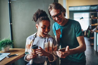 Komik video gülerek mutlu genç hipsters Smartphone cep telefonu ile sosyal ağlardan kafe iç birlikte, neşeli çok ırklı arkadaşlar cep görüntüsüyle heyecanlı fotoğraflar zevk dinlenme göz