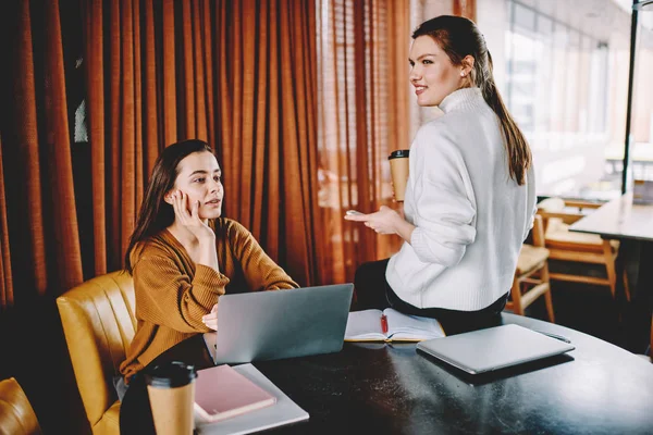 两位女学生享受团队合作 花时间一起在咖啡馆里学习 积极的时髦女孩在笔记本电脑上学习后就有了突破 并为考试寻找信息 — 图库照片