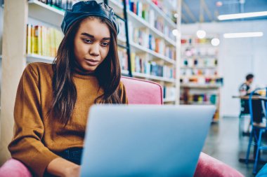 Webinar otodidakt Kitabevi, arkadaşımdan e-posta okuma ve modern Dizüstü aygıtı üzerinden cevap yazarak genç çekici kadın için vakit netbook üzerinde izlemek büyüleyici Afrika hippi kız
