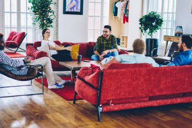 Grup gülümseyen çok ırklı insan rahat tasarım mobilya ev, söz ve having fun üzerinde ortak leisur erkek ve kadın arkadaş çeşitlilik grubu ile modern daireler dinlenme