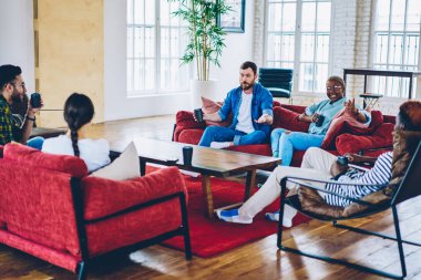 Coworking alan lounge bölgesinde iş molası sırasında iletişim ve having fun serbest zaman sırasında modern loft ofisinde genç çok ırklı arkadaşlar istirahat kadın ve erkek meslektaşlarının mutlu Grup