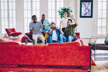 Mutlu çok memnun çok ırklı hipsters yarışma sonuçları dijital tablet, duygusal erkek ve kadın arkadaş izlerken futbol oyun kazanan ile heyecan kontrol zafer ile heyecanlı hom maçında